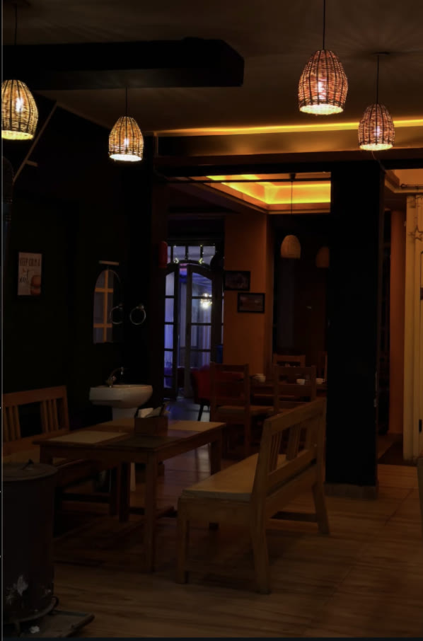 The dark, warm MoonDance café with timber tables and amber pendant lights